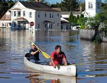 Residents canoe through floodwater