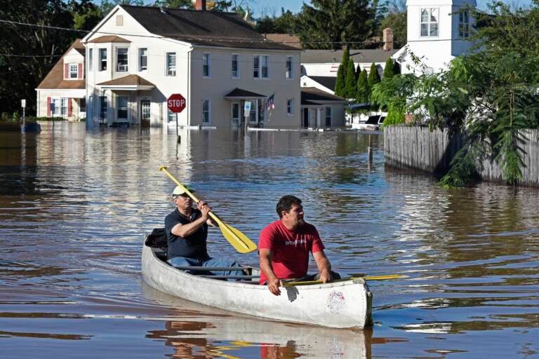 Residents canoe through floodwater