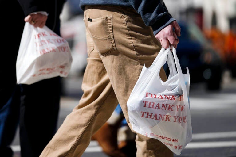 Pedestrians carry plastic bags in Philadelphia