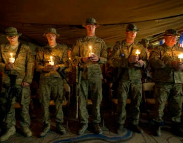 Soldiers hold up candles during a 9/11 anniversary event