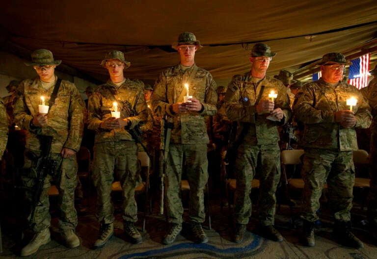 Soldiers hold up candles during a 9/11 anniversary event