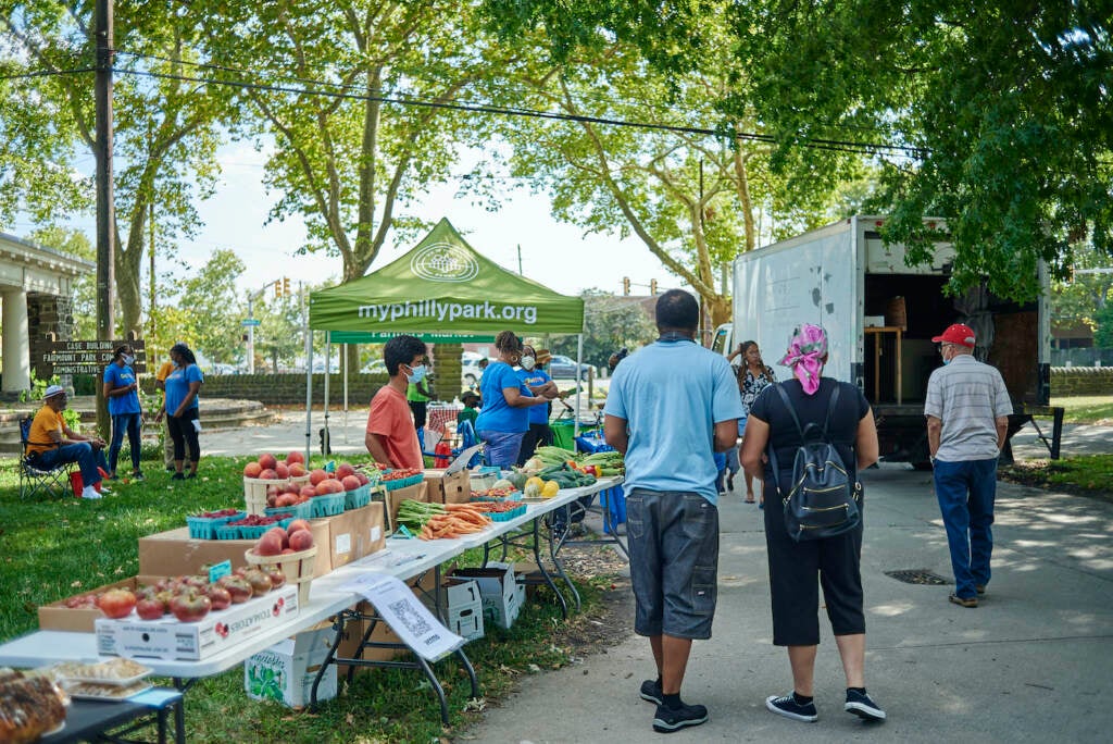 Visitors walk through the farmer's market at Fairmount Park