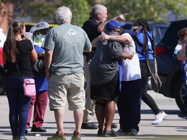 People embrace as police respond to the scene of a shooting at a Kroger's grocery store in Collierville, Tenn., on Thursday, Sept. 23, 2021