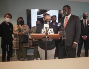 Kevin Mincey (right) comforts Rachel Briggs (left) as she speaks at a press conference