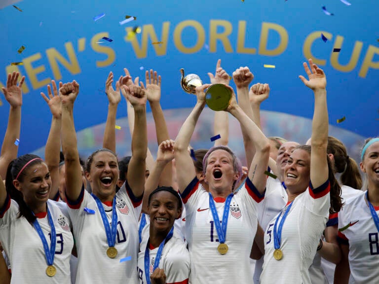 In this July 7, 2019, file photo, United States' Megan Rapinoe lifts up a trophy after winning the Women's World Cup final soccer match between U.S. and The Netherlands at the Stade de Lyon in Decines, outside Lyon, France. (Alessandra Tarantino/AP)