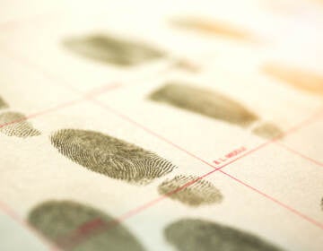 A criminal record with suspect fingerprints with a lens flare and cinematic tone