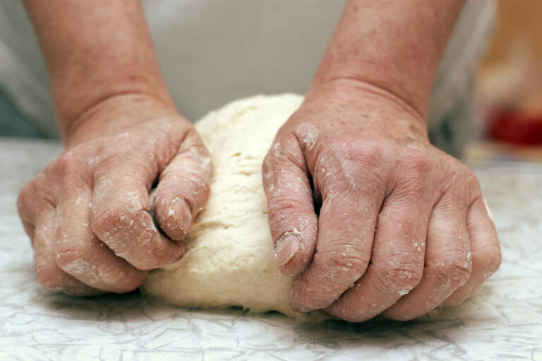 Save Download Preview Hands of woman baker kneading dough on table