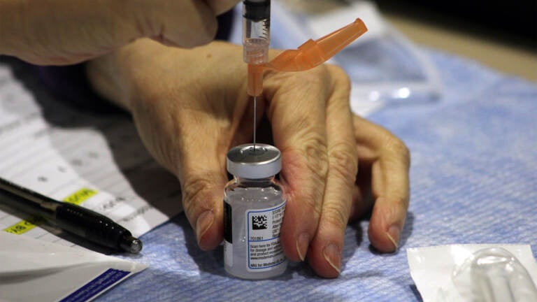 A clinician draws a dose of the Moderna COVID-19 vaccine. (FEMA)