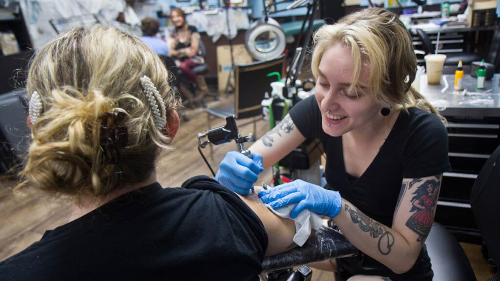 Carli Chesney receives a frog tattoo