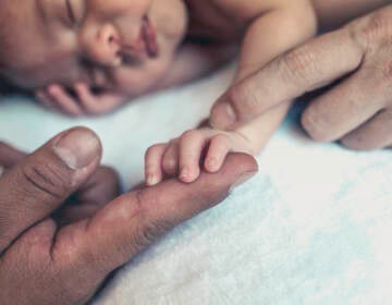 Baby holding parents hands