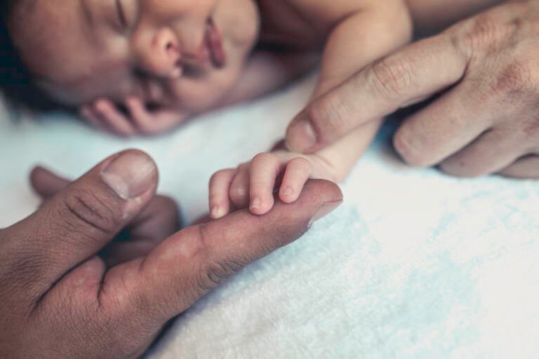 Baby holding parents hands