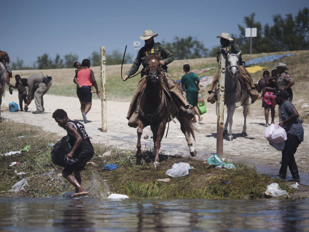 U.S. Border Patrol agents confront migrants crossing the Rio Grande River