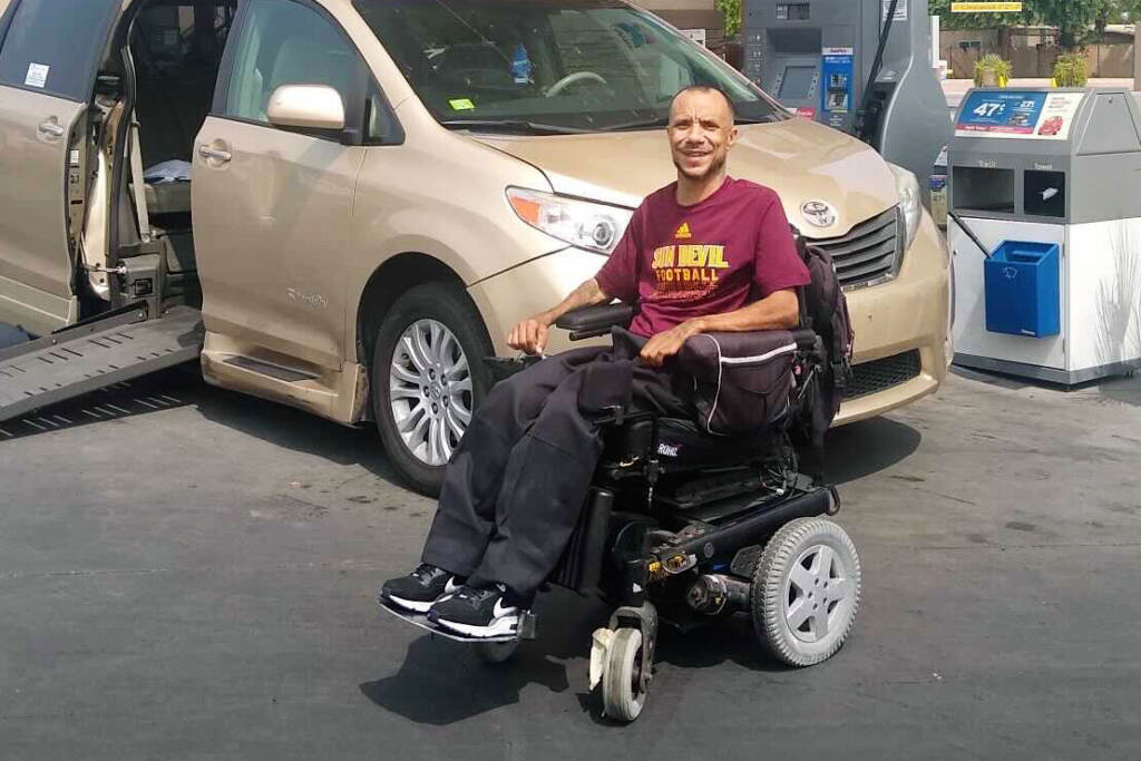 James Hinckley-Wade smiles for a photo while sitting in a wheelchair