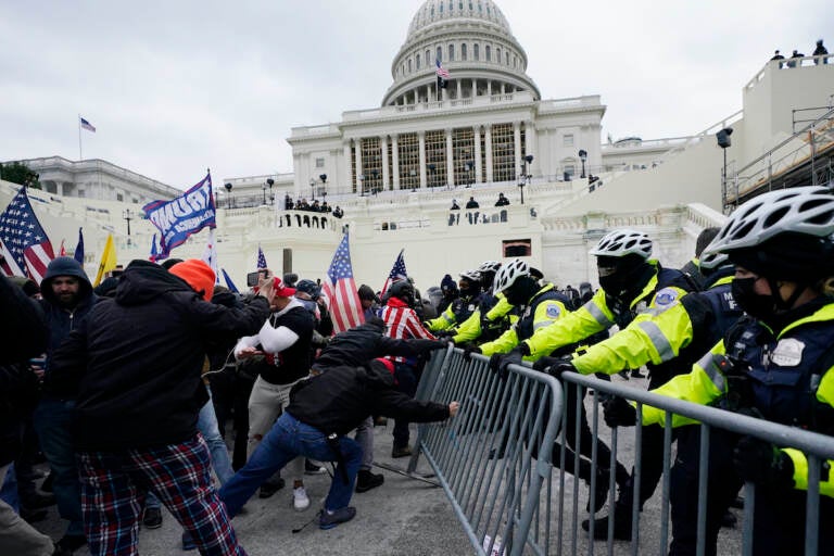 Trump supporters try to break through a police barrier, Wednesday, Jan. 6, 2021, at the Capitol in Washington. (AP Photo/Julio Cortez, File)