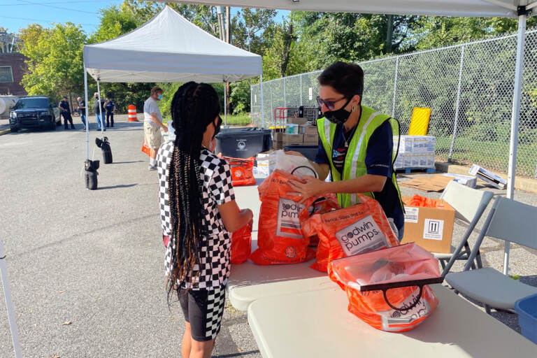 A volunteer hangs a bag of snacks to Kia Bell