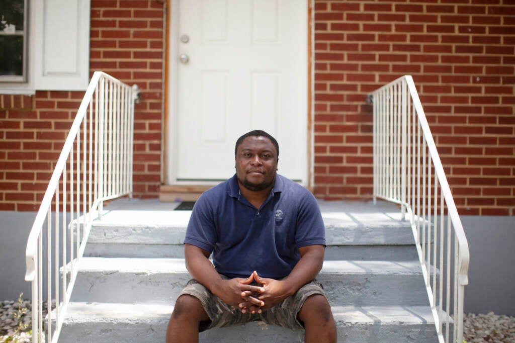 Akouete Yemey sits on his stoop