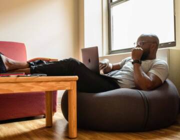 A man sitting on a bean bag chair working from home