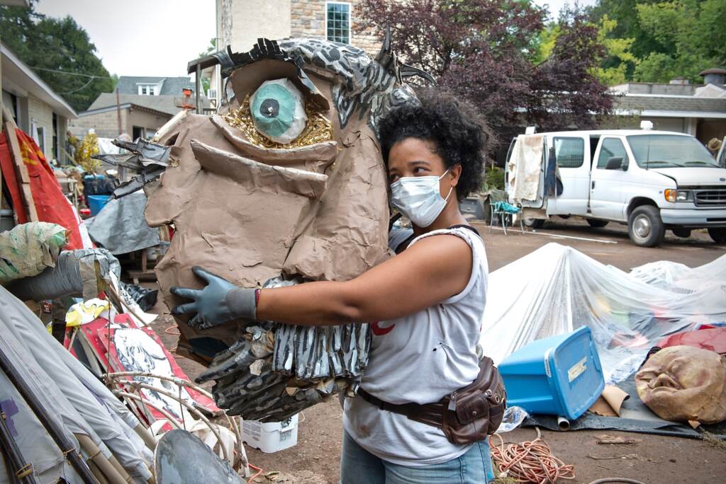 Co-artistic director Jennifer Turnbull hugs a puppet head that was made with addiction recovery residents at Girard Medical Center, as part of its arts therapy program. It survived the flood