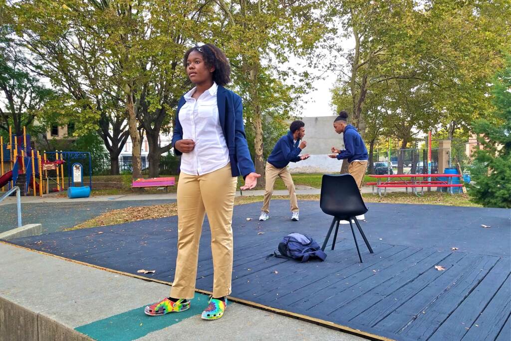 During a rehearsal of ''Town Hall Resolution 50'' in Camden's Northgate Park, Eva Vanterpool delivers a monologue as co-stars Carmi Jackson and Jamall Phillips play rock, paper, scissors behind her