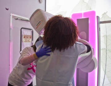 Staff of Penn Medicine’s mobile mammography unit demonstrate how patients receive a mammogram on Oct. 22, 2021 in Philadelphia. (Kimberly Paynter/WHYY)