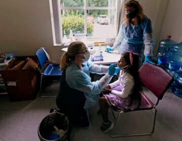 School nurse Denise Corrigan, left, tests a student for COVID-19 at the E.N. White School in Holyoke, Mass., on Wednesday, Aug. 4, 2021. (AP Photo/Charles Krupa)