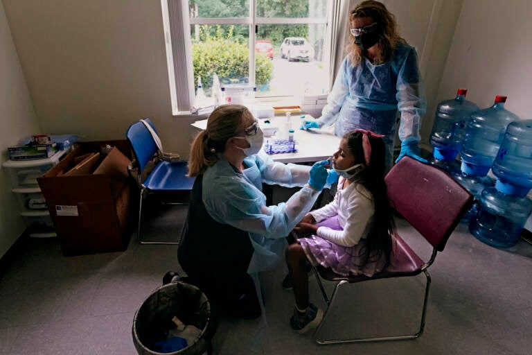 School nurse Denise Corrigan, left, tests a student for COVID-19 at the E.N. White School in Holyoke, Mass., on Wednesday, Aug. 4, 2021. (AP Photo/Charles Krupa)