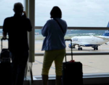 Travelers watch a JetBlue Airways aircraft taxi away from a gate at Ronald Reagan Washington National Airport†ahead of Memorial Day weekend, Tuesday, May 25, 2021, in Arlington, Va