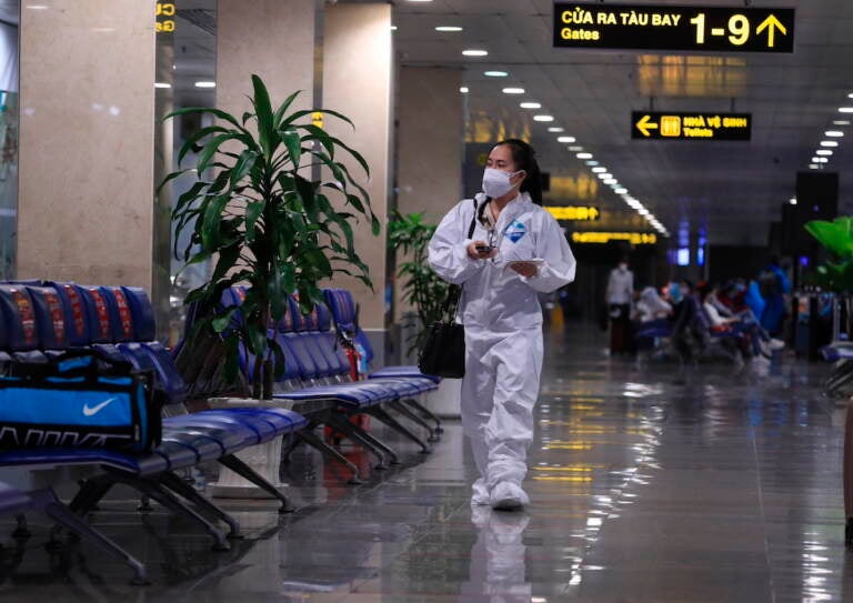 A passenger in full protective suit walks to boarding gate at Tan Son Nhat airport in Ho Chi Minh city, Vietnam on 15 Oct. 2021. Vietnam has resumed air travel after several months of suspension due to COVID-19 outbreak