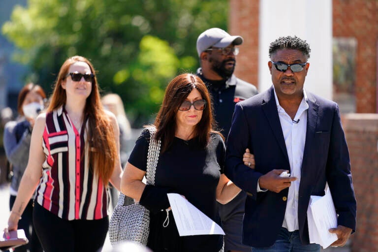 File photo: Former NFL players Ken Jenkins, right, and Clarence Vaughn III, center right, along with their wives, Amy Lewis, center, and Brooke Vaughn, left, carrie tens of thousands of petitions demanding equal treatment for everyone involved in the settlement of concussion claims against the NFL, to the federal courthouse in Philadelphia, Friday, May 14, 2021