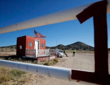 Private security stand at the entrance of the Bonanza Creek Film Ranch in Santa Fe, N.M., Friday, Oct. 22, 2021. Actor Alec Baldwin fired a prop gun on the set of a Western being filmed at the ranch on Thursday, Oct. 21, killing the cinematographer, officials said. The director of the movie was wounded, and authorities are investigating