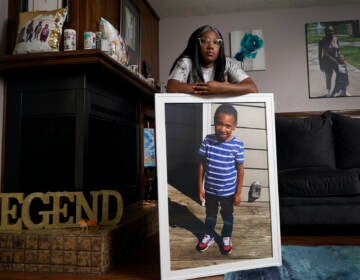 Charron Powell stands with a photo of her son, LeGend Talieferro, at her home