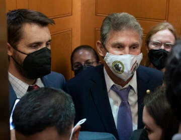 Sen. Joe Manchin, D-W.Va., squeezes into an elevator with White House domestic policy adviser Susan Rice, center, Director of the National Economic Council Brian Deese, left, and other White House officials