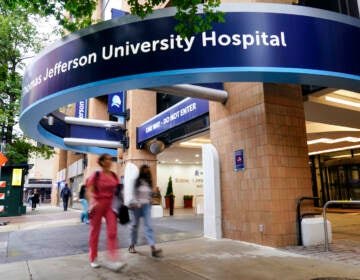 Pedestrians walk past Thomas Jefferson University Hospital