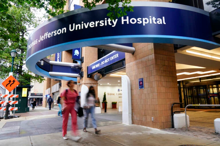 Pedestrians walk past Thomas Jefferson University Hospital