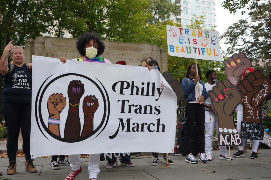 Roberto Thornton, one of the organizers, carries the banner as he waits for an attendee to do the honors