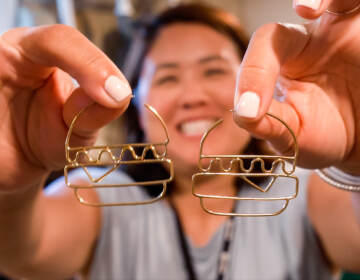 Shirley Minn holding a pair of hamburger earrings from Anethum Jewelry