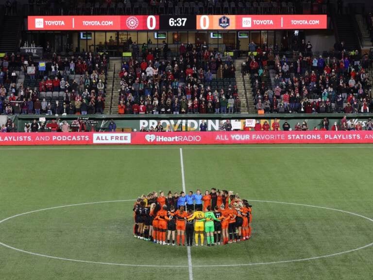 Portland Thorns and Houston Dash players, along with referees, gather at midfield, in demonstration of solidarity with two former NWSL players who came forward with allegations of sexual harassment and misconduct against a prominent coach, during the first half of an NWSL soccer match in Portland, Ore., Wednesday, Oct. 6, 2021