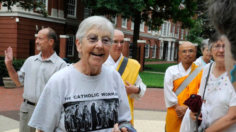 FILE - In this Aug. 9, 2012, file photo, Sister Megan Rice, center, and Michael Walli, in the background waving, are greeted by supporters as they arrive for a federal court appearance in Knoxville, Tenn., after being charged with sabotaging a government nuclear complex. Rice, who served two years in prison and was released when her original conviction was thrown out by a federal appeals court, died of congestive heart failure Oct. 10, 2021, at Holy Child Center in Rosemont, Pa. She was 91. (Michael Patrick/Knoxville News Sentinel via AP, File)