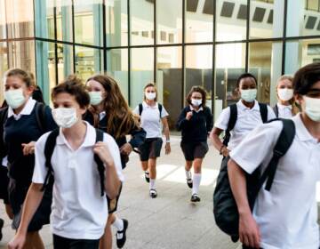 High school students wearing masks on their way home