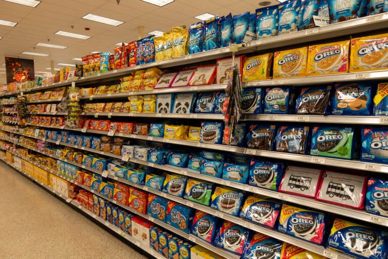 The cookie aisle in a grocery store with two people shopping.