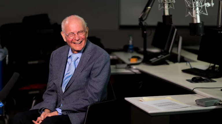 Bill Siemering sits at a desk