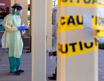 SAN PABLO, CA -  APRIL 24: Dr. Melina Beaton wears full personal protective equipment while administering a swab test on a patient at a walk-up coronavirus testing site at West County Health Center in San Pablo, Calif. Friday, April 24, 2020. California Governor Gavin Newsom says the state will need to test 60,000 to 80,000 each day in order to safely reopen society, with essential workers being tested more frequently than others. The state plans to open 86 new testing sites in 