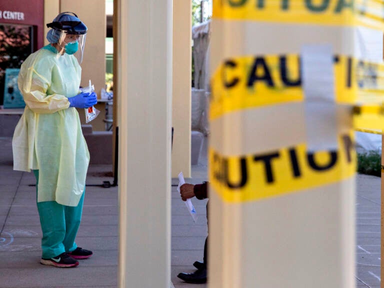 SAN PABLO, CA -  APRIL 24: Dr. Melina Beaton wears full personal protective equipment while administering a swab test on a patient at a walk-up coronavirus testing site at West County Health Center in San Pablo, Calif. Friday, April 24, 2020. California Governor Gavin Newsom says the state will need to test 60,000 to 80,000 each day in order to safely reopen society, with essential workers being tested more frequently than others. The state plans to open 86 new testing sites in 