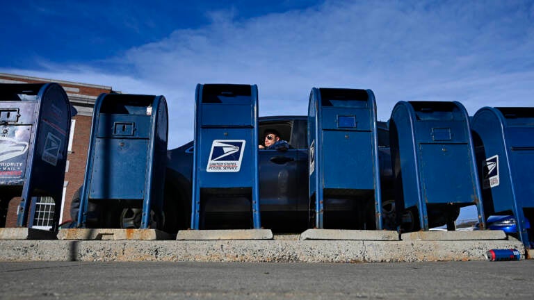 A man pulls up to drop off mail at the mailboxes at the Portland Post Office in Portland, Maine, on Dec. 4, 2020. A man pulls up to drop off mail at the mailboxes at the Portland Post Office