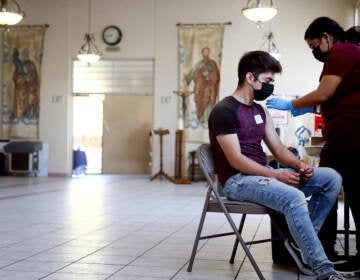 A person receives their first dose of the Pfizer COVID-19 vaccine at a clinic targeting minority community members at St. Patrick's Catholic Church on April 9, 2021 in Los Angeles, California. (Photo by Mario Tama/Getty Images)