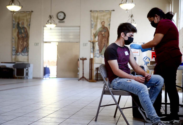 A person receives their first dose of the Pfizer COVID-19 vaccine at a clinic targeting minority community members at St. Patrick's Catholic Church on April 9, 2021 in Los Angeles, California. (Photo by Mario Tama/Getty Images)