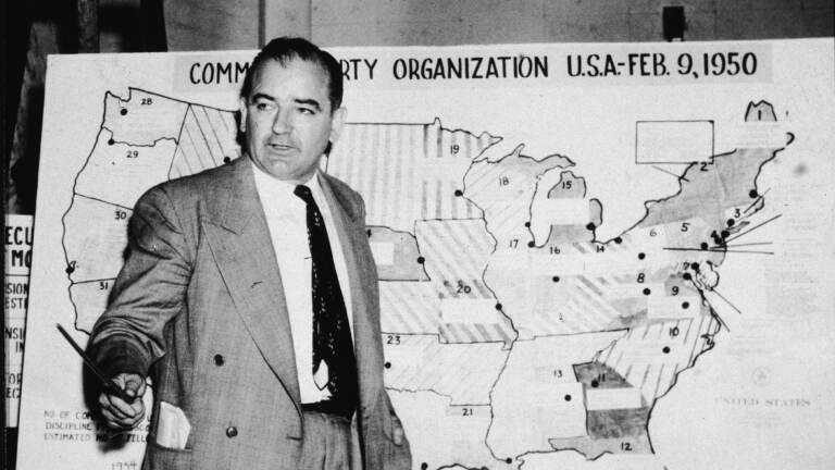 Sen. Joseph McCarthy, R-Wis., testifies during hearings in Washington, D.C., on June 9, 1954. McCarthy stands before a map that charts alleged communist activity in the United States. (Getty Images)