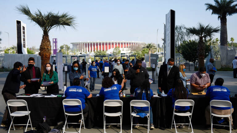 People receive information as they attend a job fair for employment with SoFi Stadium and Los Angeles International Airport employers, at SoFi Stadium on September 9, 2021, in Inglewood, California. - Fewer Americans made new claims for unemployment benefits last week than at any point since the Covid-19 pandemic began, according to government data released on September 9, the latest sign of progress in the job market following last year's mass layoffs. (Photo by Patrick T. FALLON / AFP) (Photo by PATRICK T. FALLON/AFP via Getty Images)