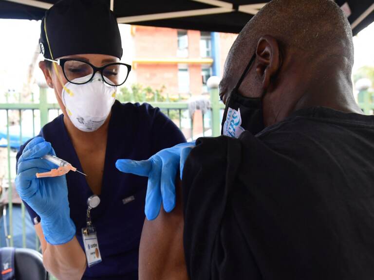 Nurse Christina Garibay administers Johnson & Johnson's COVID vaccine to a man at a community outreach event in Los Angeles in August.
(Frederic J. Brown/AFP via Getty Images)