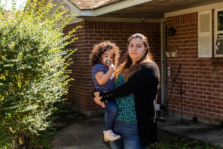 Erica Cuellar and her daughter Sara Alvarado pose for a portrait in front of their home